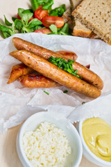 Fried sausage with mustard and horseradish, bread on wooden table