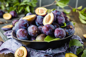 close-up view of fresh organic juicy plums in bowl on table 