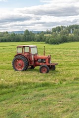 Red tractor in farming landscape