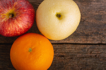 Apple, Orange and Asian Pear on Wooden Table.