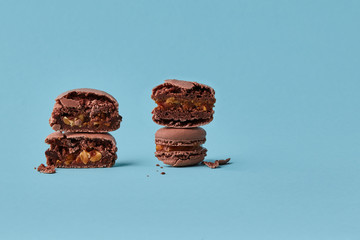 Close-up studio shot of tasty chocolate macarons on blue background.