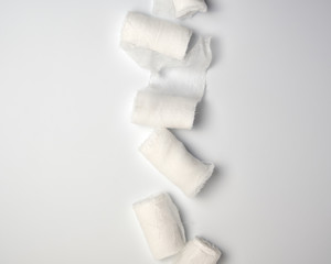 rolled up white sterile medical bandages on a white background