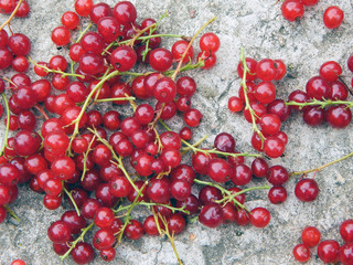 Juicy ripe red currant lying on a concrete background