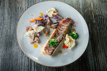 finely decorated healthy baked fish fillet and vegetables