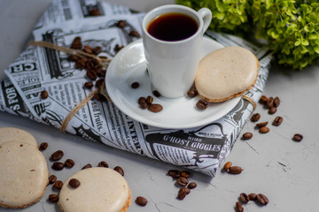 I wrapped a gift in wrapping paper. A cup of coffee will help you relax. Next to it is a delicious bisse. All on a light background. 