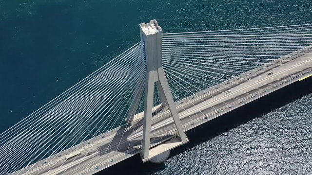 Aerial drone video of world famous cable suspension bridge of Rio - Antirio Harilaos Trikoupis, crossing Corinthian Gulf, mainland Greece to Peloponnese, Patras