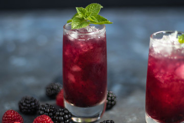 Tincture of vodka and blackberry of homemade production. Glasses are filled with crushed ice and decorated with mint tones.