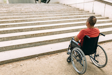 man in wheelchair stopped because of staircase