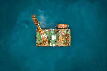 Industrial platform in ocean or tower with crane or science sea research center, aerial top view...