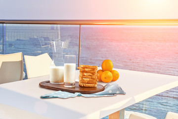 Table for two served with a breakfast on outdoor hotel balcony with a sea view.