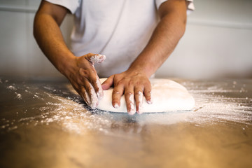 A man decorates and makes cakes in a pastry shop