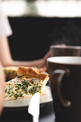 the process of eating girls in a cafe. Close up Photo of female hands holding fork and knife cutting a piece of salty pie