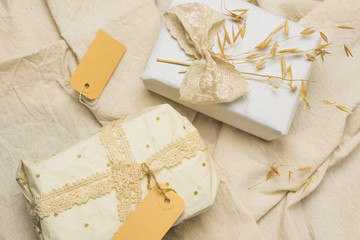 Beautifully wrapped gift boxes with tags on textured fabric