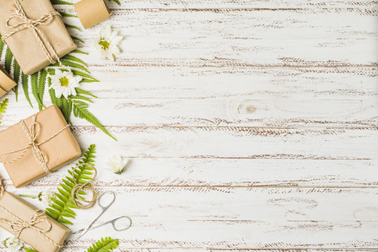 Brown parcel tied with string and white flower on desk