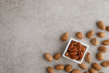 Frame of pecan nuts on marble background. Square bowl of nuts in the corner