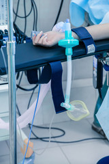 patient's hand in the operating room and breathing mask