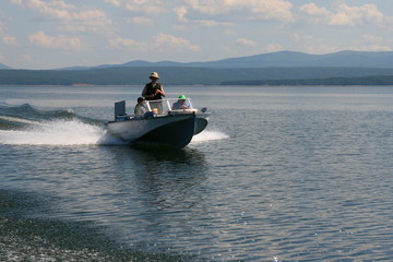Fototapeta premium Motor boat floats quickly on the surface of the sea.