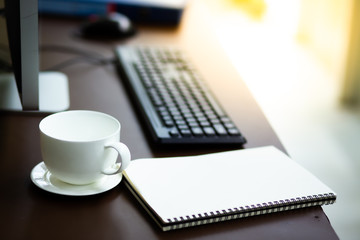 Business SME owner desk with notebook glass computer and white cup coffee at home business