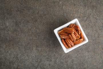 White square bowl of pecan nuts. Healthy eating concept
