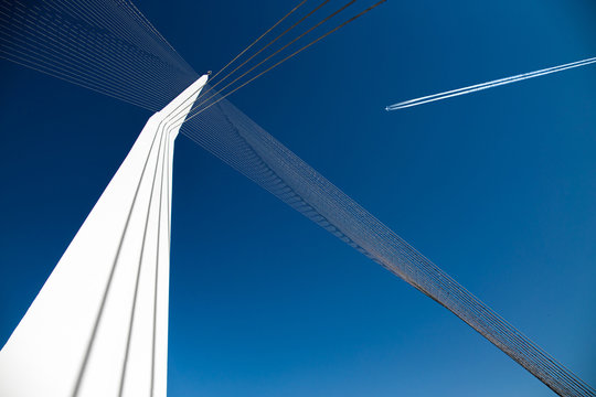 high flying plane, blue sky and white column with cables