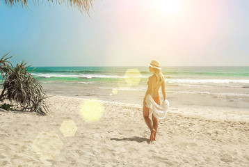Fototapeta na wymiar Happy traveller woman in white enjoys her tropical beach vacatio