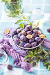 close-up view of fresh organic juicy plums in bowl on table 