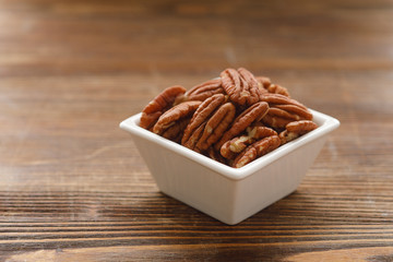 White square bowl of pecan nuts. Healthy eating concept