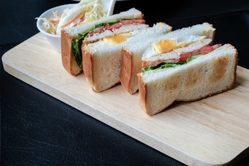 Freshly made club sandwiches served on a wooden chopping board