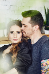 Couple in love has Breakfast in the kitchen early in the morning. Hugs and kisses, sexy girl in Bathrobe and man. Weekend morning in the kitchen