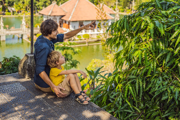 Dad and son in Water Palace Soekasada Taman Ujung Ruins on Bali Island in Indonesia. Amazing old architecture. Travel and holidays background. Traveling with kids concept. Kids Friendly places