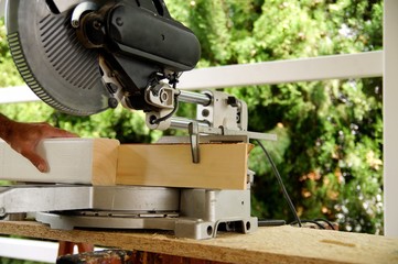 carpenter using a circular saw to cut a wooden beam. Woodworking and carpentry production. Wooden beams spruce for outdoor construction, wood beams for carport. woodwork concept.man's hands is working