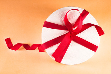 White box with a red bow, on a colored background