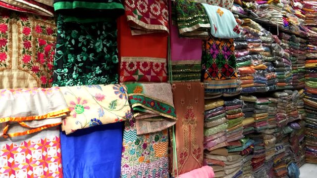 a tilt down shot of garments for sale at hall bazaar in amritsar, india