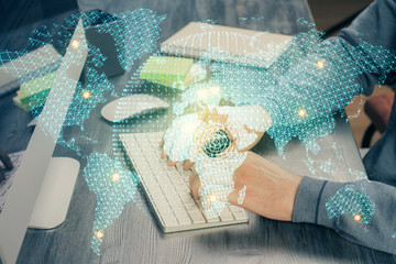 Double exposure of businessman working on laptop on background. International business hologram in...