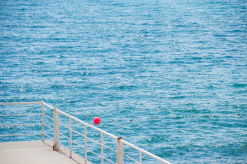 view from the pier to the blue sea surface. Beautiful coast in the city.