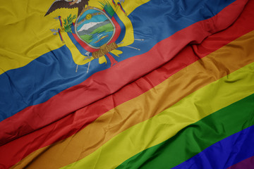 waving colorful gay rainbow flag and national flag of ecuador.