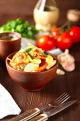 Country stew with meat, potato, tomato onion and cheese in clay bowl on rustic table served for dinner