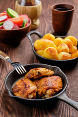 Roasted chicken thighs, fried potato and salad - rustic dinner