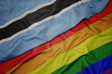waving colorful gay rainbow flag and national flag of botswana.