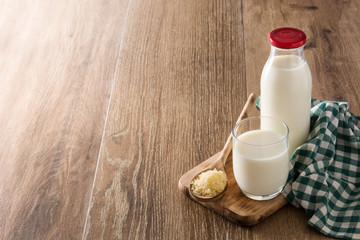 Rice milk in glass and bottle on wooden table. Copyspace