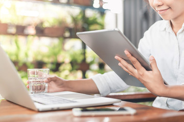 Young beautiful professional female freelancer making researches while surfing in internet during distance work on laptop computer.Pensive copywriter watching training webinar in webpage on gadget
