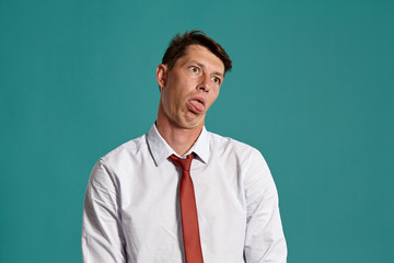 Young man in a classic white shirt and red tie posing over a blue background.