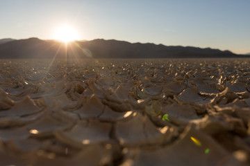 Obraz premium Cracked playa mud texture from the desert to the mountains at sunset