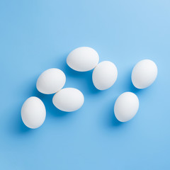 White eggs arrangement on blue background