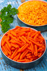 Orange gluten free diet pasta made from lentils  legumes on blue wooden table