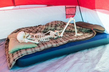 Skeleton relaxing in a tent while camping