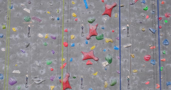 Climbing routes with plastic holds, on an indoor climbing wall - tilt up. 4K DCI, 200 Mbps.