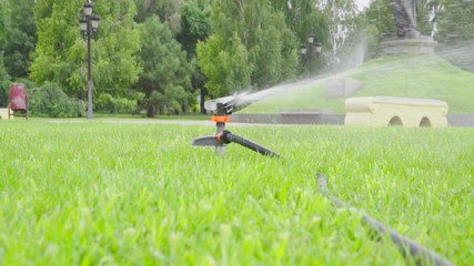  Grass lawn. Watering with sprinkling machine 