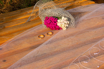 wedding rings lie on a grid. Wedding rings lie on the flowers of carnations.