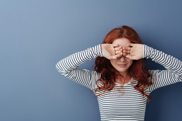 Young woman covering her eyes with her hands